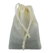 Cream colored drawstring velveteen bag shown closed holding a stone rune set.